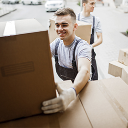 Deux hommes en tenue de travail chargent des cartons dans un camion pour un déménagement.